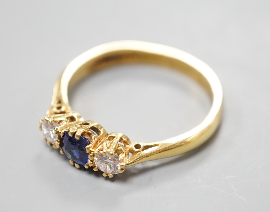 A modern 18ct gold, sapphire and diamond set three stone ring, size S, gross weight 4.4 grams